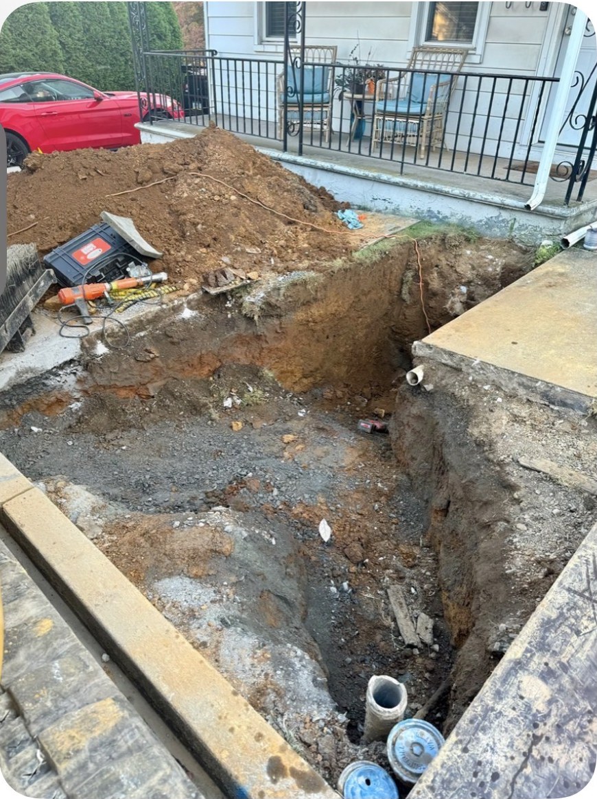 Open excavation for a sewer lateral repair beside a residential front porch in Fountain Hill, PA